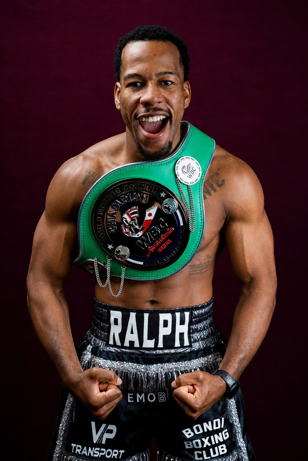 Etienne Ralph smiling with the WBC belt over his shoulder