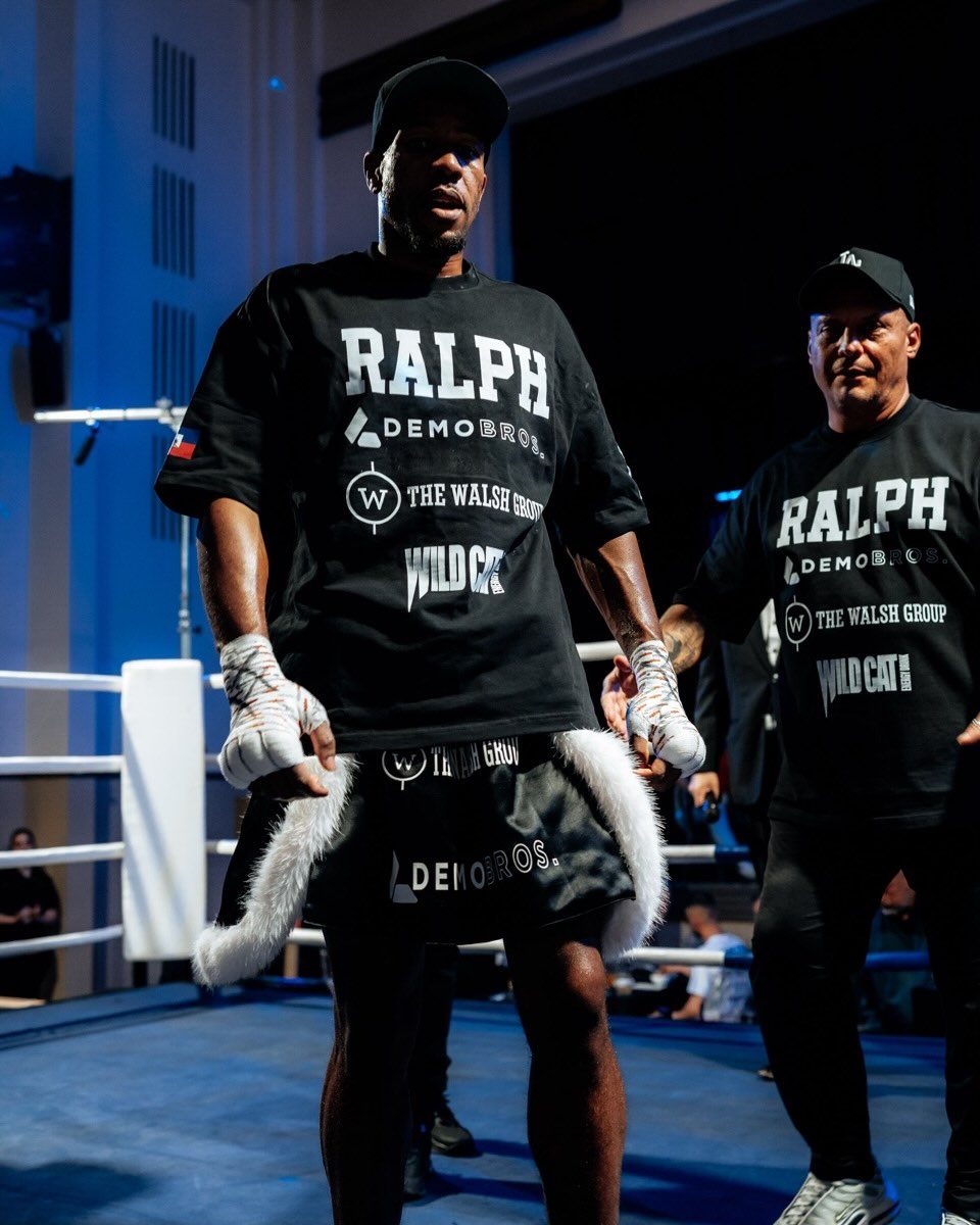 Etienne Ralph walking out to the ring with his Bondi Boxing Club corner, in blue light